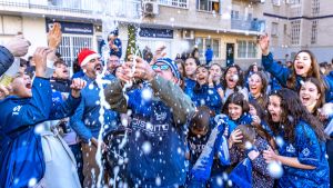 Las jugadoras y aficionados de Distrito Olímpico celebran El Gordo lanzando champán.