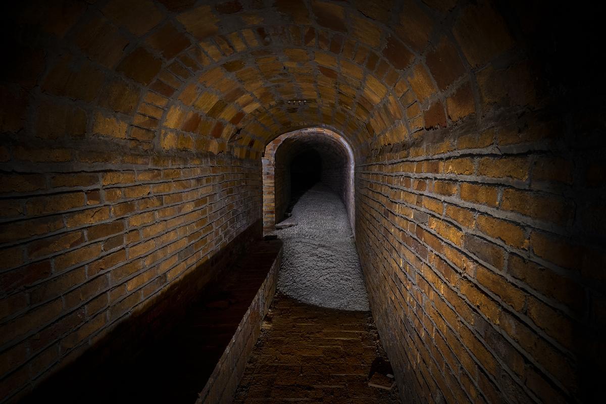 Una lengua de cemento procedente de unas obras de la superficie inunda parte del refugio del pasaje Simó.