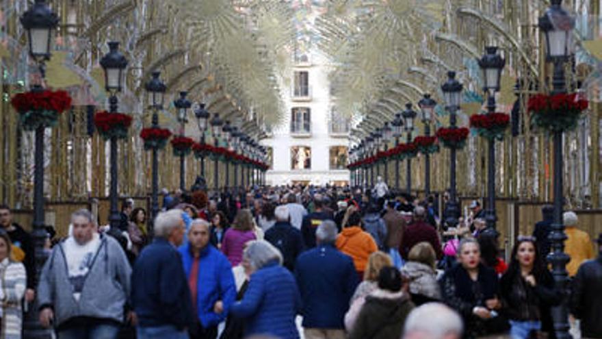 Turistas pasean por la calle Larios.