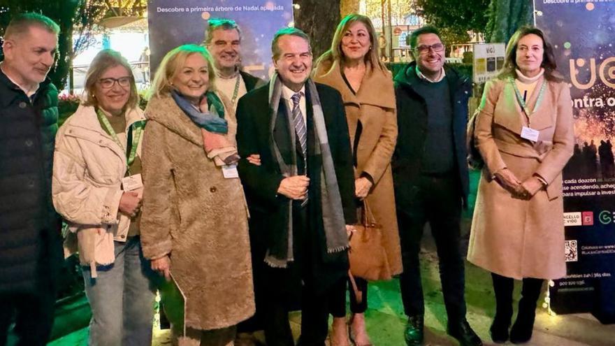 Caballero, Rivas y Aguiar, con representantes de la AECC junto al árbol en Praza de Compostela.