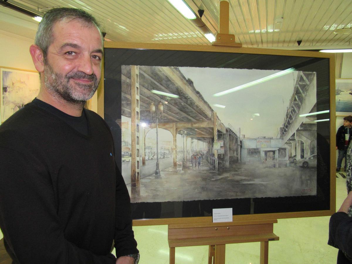 Uno de los ganadores recientes del certamen junto a su obra