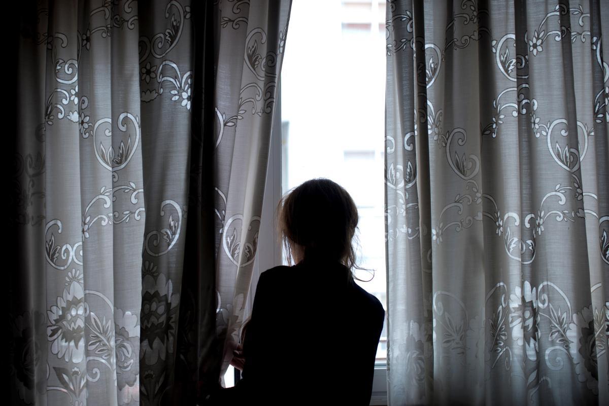 Una mujer mira por la ventana, en abril del 2020, en pleno estado de alarma en España.
