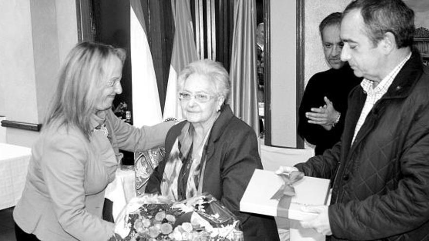 Ana García, de la Asociación de Hostelería, y el alcalde, Ángel Riego, entregan regalos a Rosa Fernández en el restaurante La Fonte de Candás.