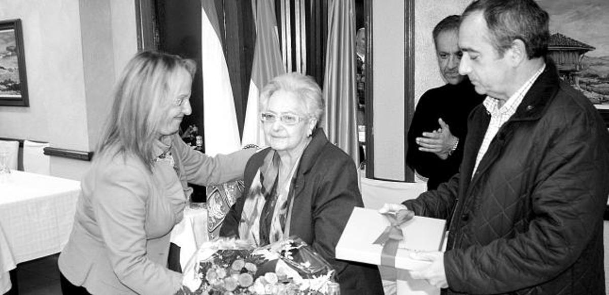Ana García, de la Asociación de Hostelería, y el alcalde, Ángel Riego, entregan regalos a Rosa Fernández en el restaurante La Fonte de Candás.