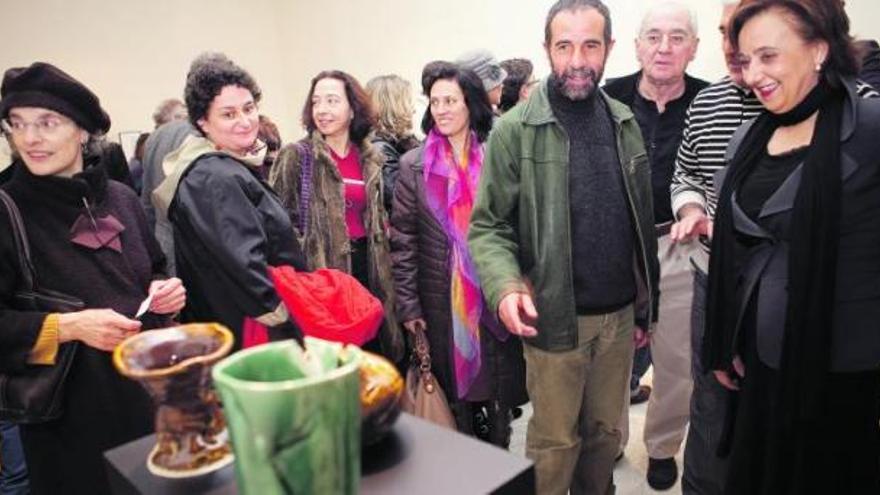 Mercedes Álvarez, a la derecha, comenta con Vicente Pastor sus piezas de cerámica; entre ambos, Emilio Marcos, director del museo.