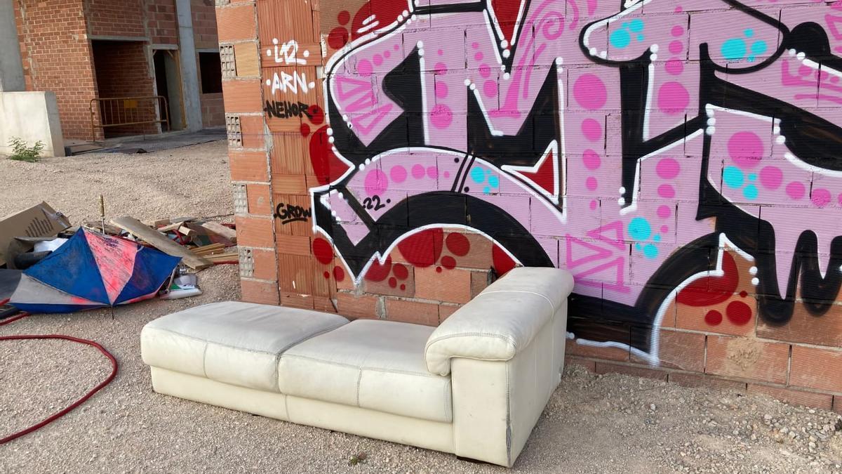 Un sofá junto a una gran pintada.