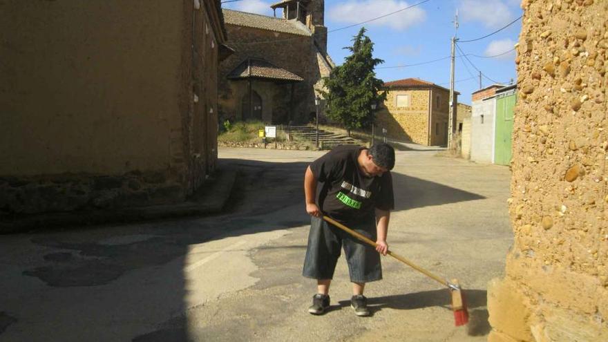 Un operario del Ayuntamiento limpia la calle de la iglesia de Grijalbar.