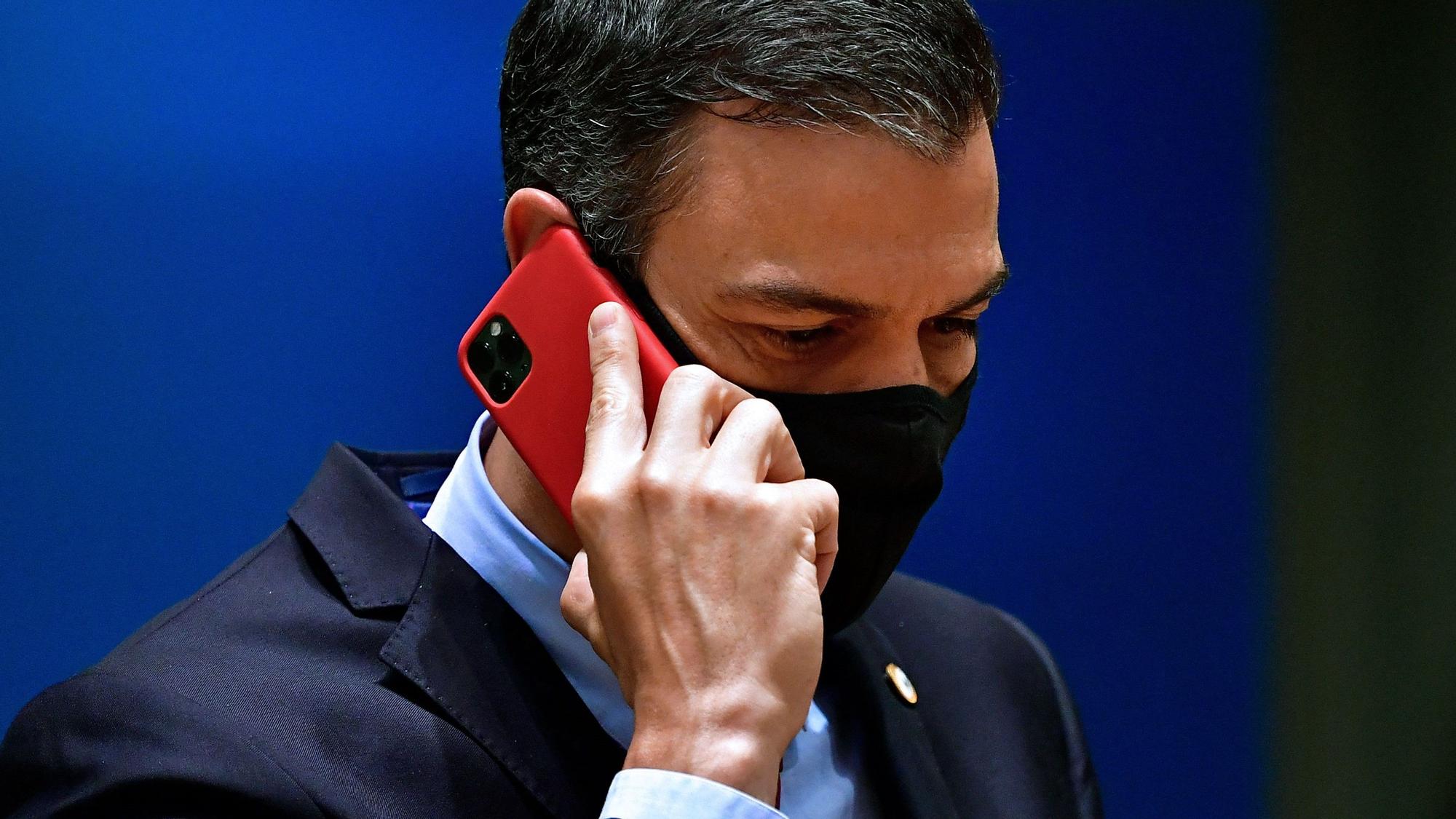 In this file photo taken on July 20, 2020 Spain's Prime Minister Pedro Sanchez phones during an EU summit in Brussels. - Spain said on May 2, 2022 that the mobile phones of Prime Minister Pedro Sanchez and Defence Minister Margarita Robles were tapped using Pegasus spyware in an &quot;illicit and external&quot; intervention. (Photo by JOHN THYS / POOL / AFP)