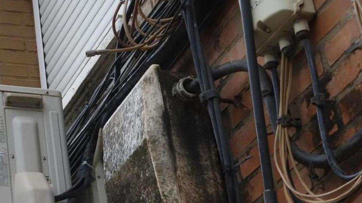 Cableado eléctrico en la fachada de un edificio. Imagen de archivo.
