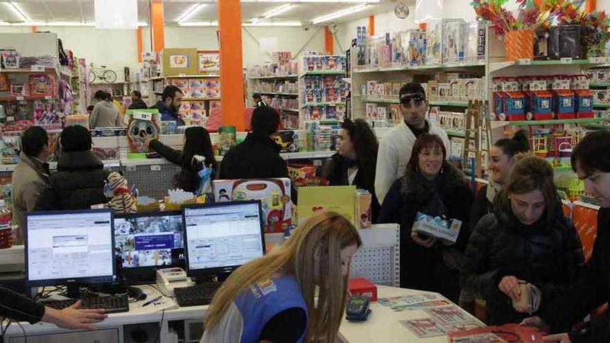 Varias personas hacen cola para pagar en una juguetería de la capital durante la jornada de ayer.