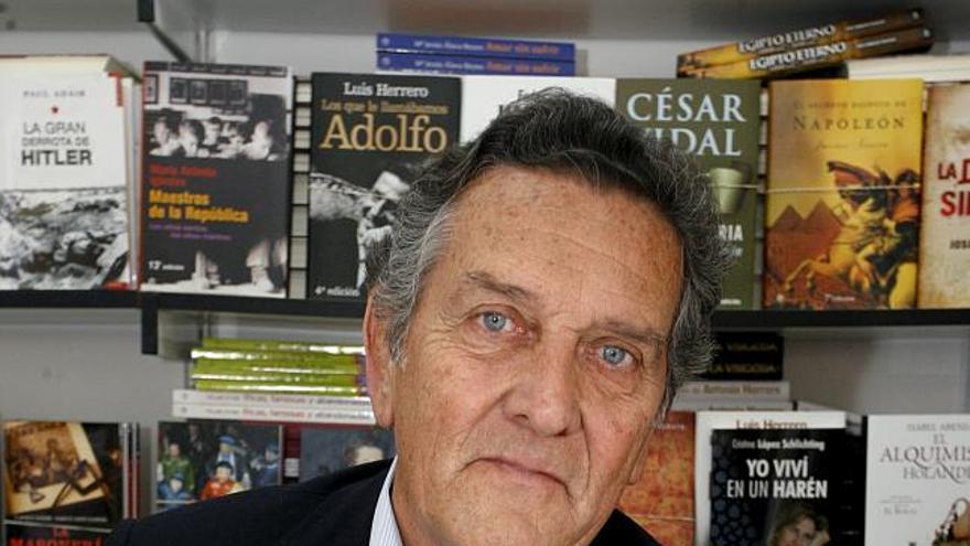 El escritor Fernando Schwartz espera en una caseta de la Feria del Libro de Madrid, que cumplió su primera semana, para firmar ejemplares de su libro a sus admiradores.