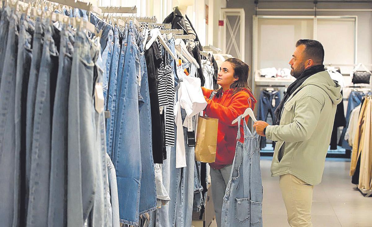 Una joven observa las prendas vaqueras en un establecimiento.