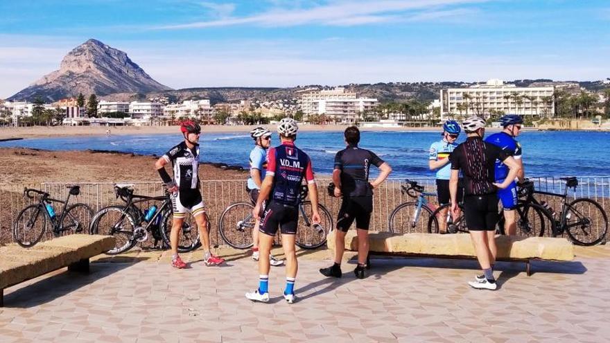 Aficionados al ciclismo, en la playa del Arenal de Xàbia.