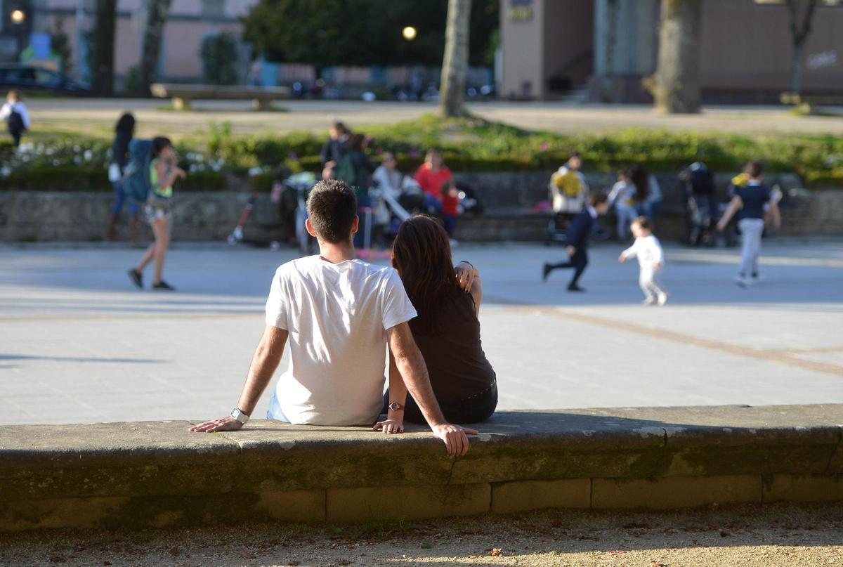 Una joven pareja, frente a un parque infantil de Vigo.