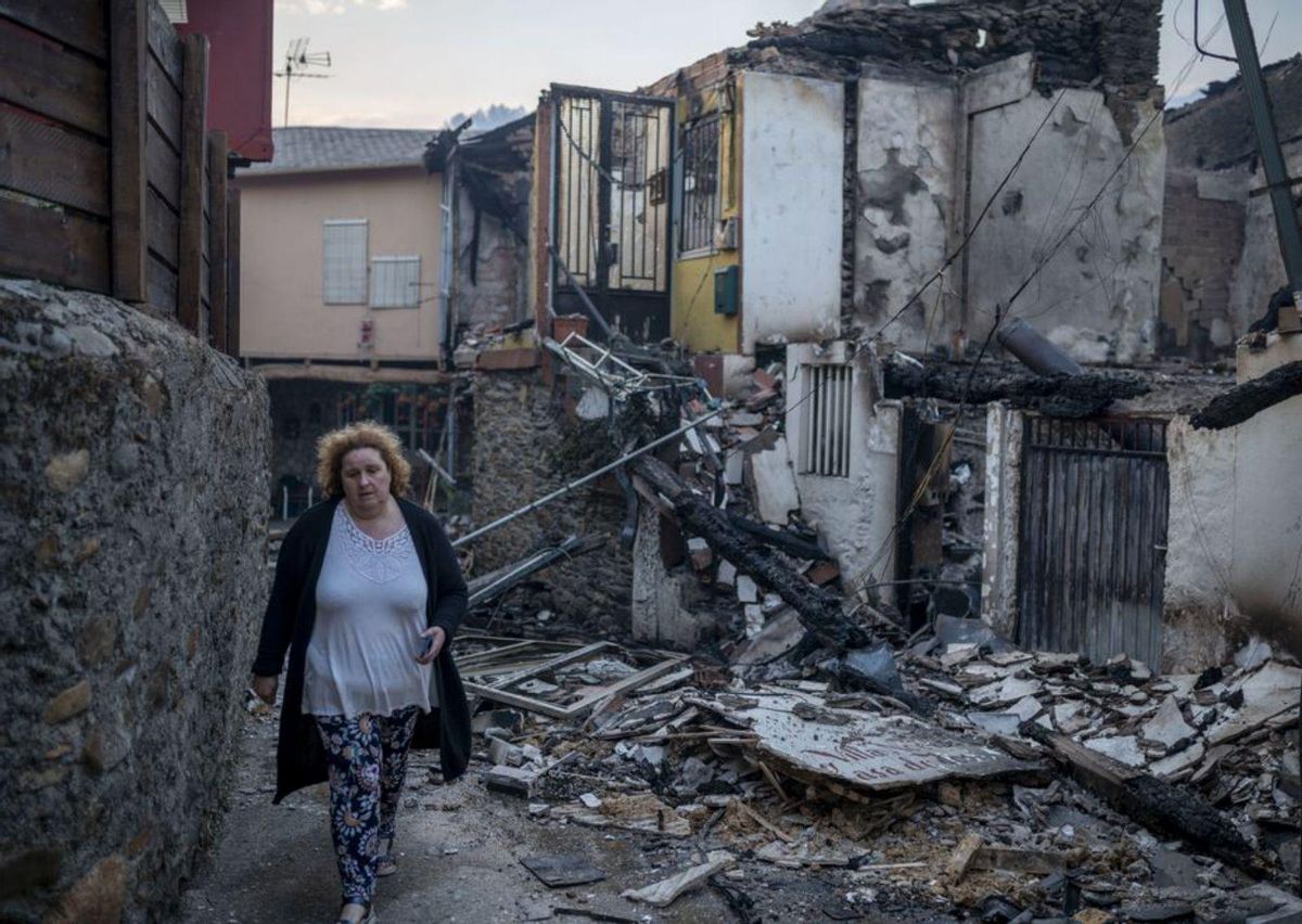 Una vecina camina por A Veiga da Cascallá. | // BRAIS LORENZO