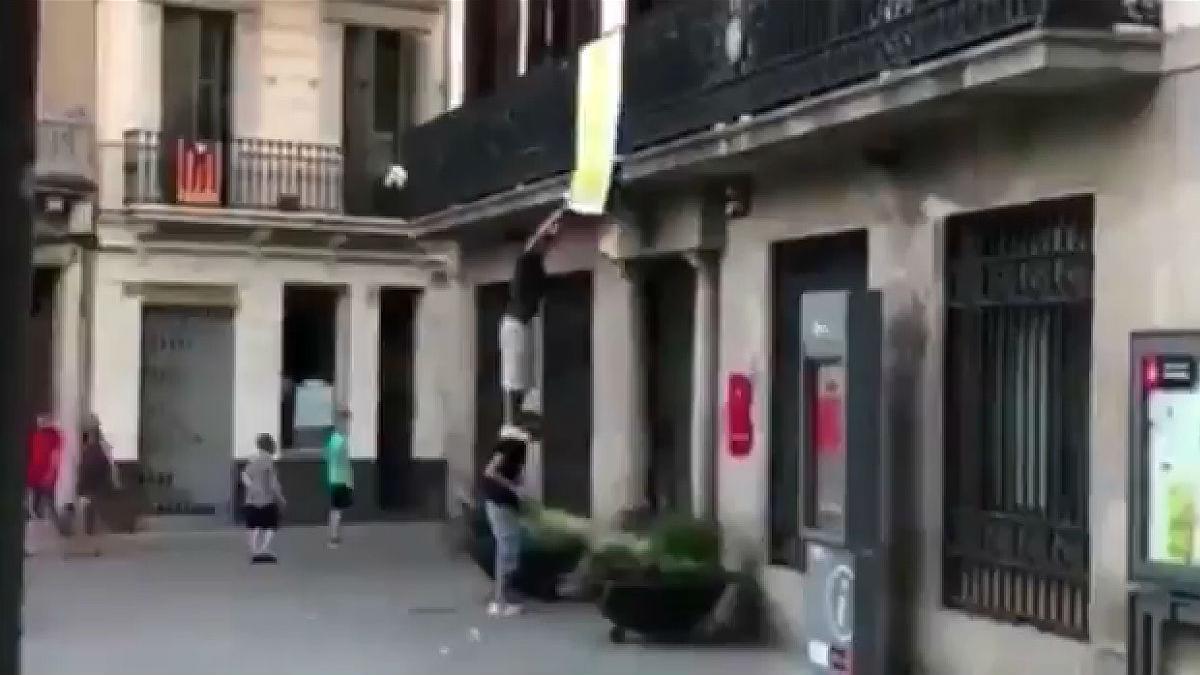 Dos hombres arrancan el lazo amarillo de la sede de Sant Andreu