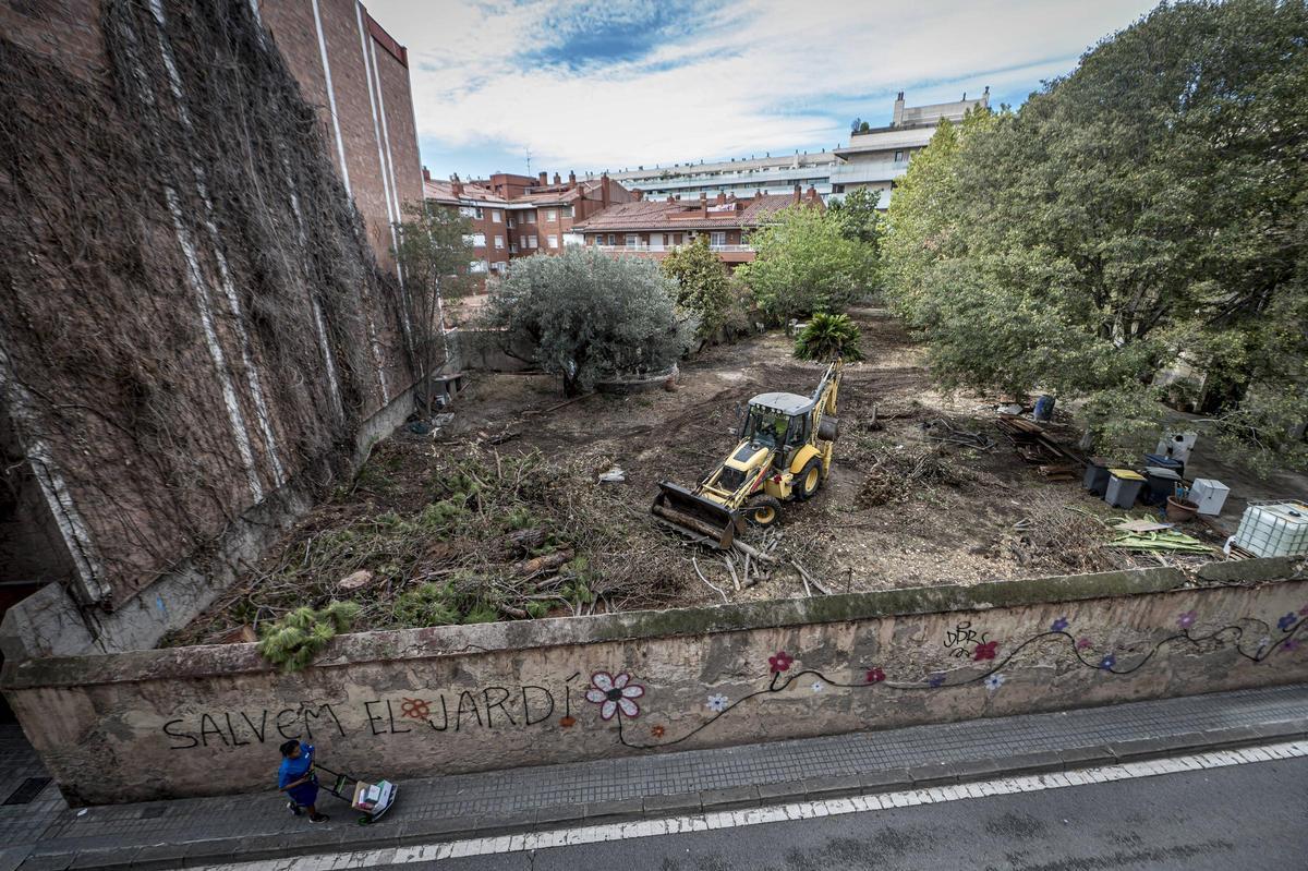 Una retroexcavadora remolca troncos talados dentro del jardín de la masía de Can Raventós, en Barcelona, en el verano de 2023.