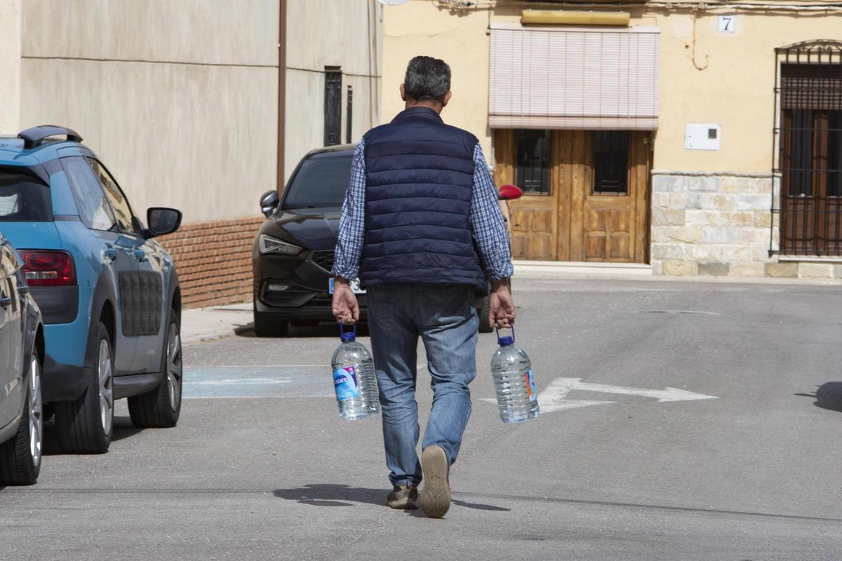 Un hombre carga dos garrafas de agua en la Torre.