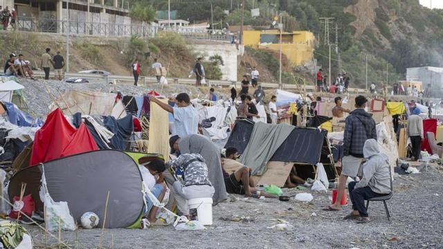 Desenes de migrants acampats a la platja d’El Trampolín de Ceuta, divendres passat. | MARCOS MORENO / EUROPA PRESS