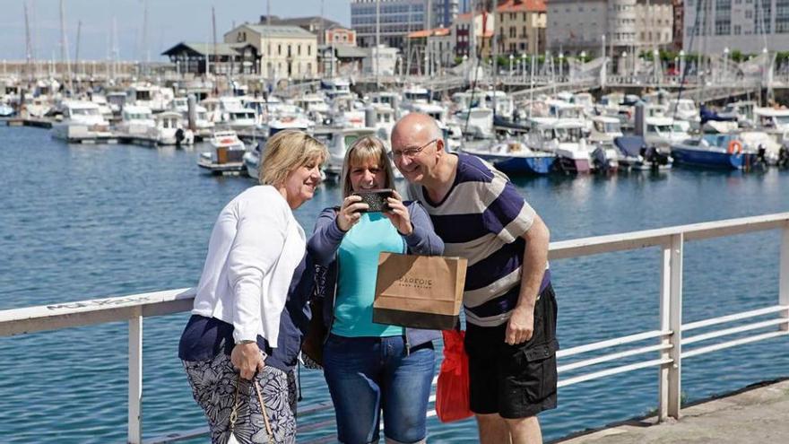 Turistas haciéndose una fotografía en el puerto deportivo local.