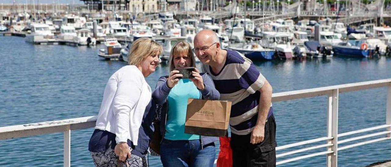 Turistas haciéndose una fotografía en el puerto deportivo local.