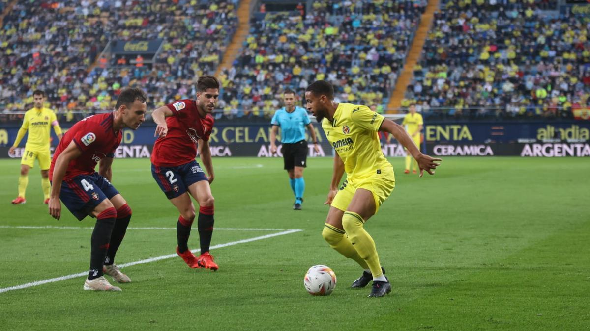 Arnaut Danjuma intenta encarar ante la presión de dos futbolistas visitantes.