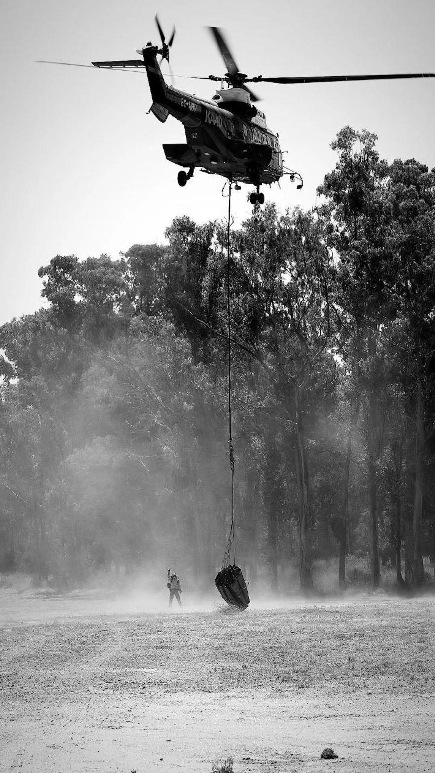 Un helicóptero del Infoca, durante las labores de extinción en el incendio de Pujerra