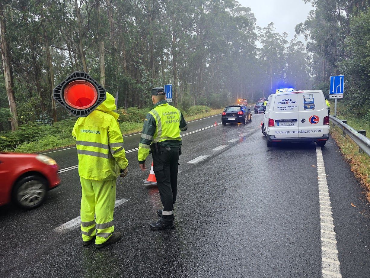 Un agente y un operario del servicio de mantenimiento de carreteras tras un accidente ocurrido en Catoira.