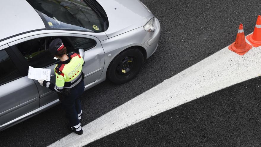 Un agent dels Mossos, demana la documentació a un conductor durant un control policial