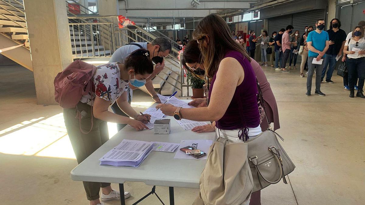 Unas jóvenes firman elconsentimiento para recibirlas segundas dosis en elestadio Enrique Roca.