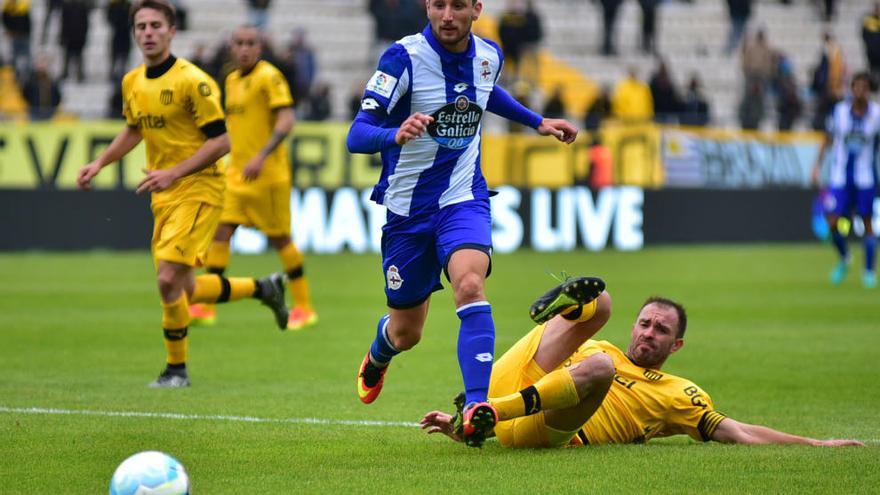 El deportivista Borja Valle disputa el balón al jugador de Peñarol Carlos Valdez.