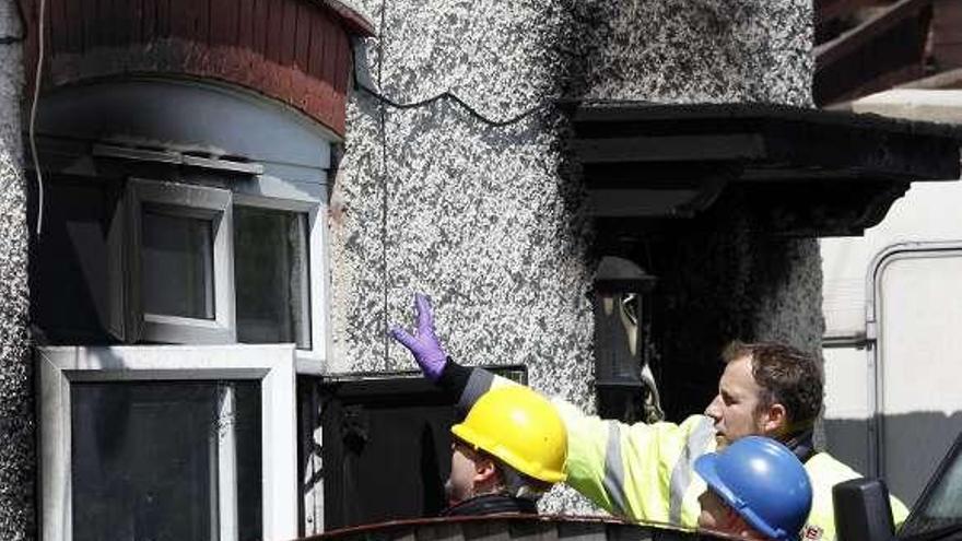 Bomberos trabajan en la casa donde se registró el fuego. / reuters