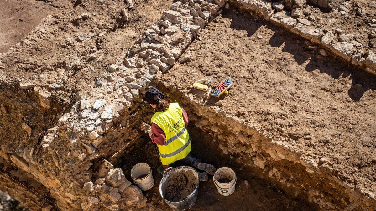 La restauradora del proyecto trabaja en uno de los muros de las casas.