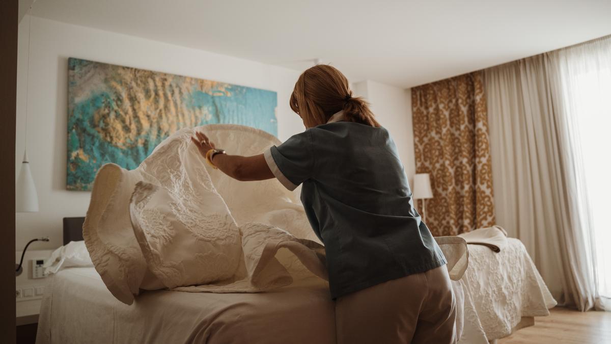 Una camarera de piso haciendo una cama elevable en un hotel de Mallorca.