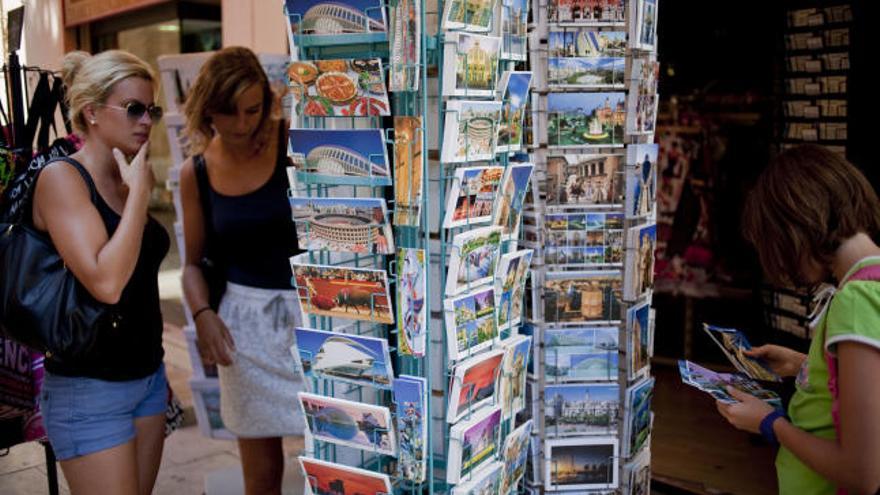 Varias turistas buscan recuerdos de la ciudad de Valencia.