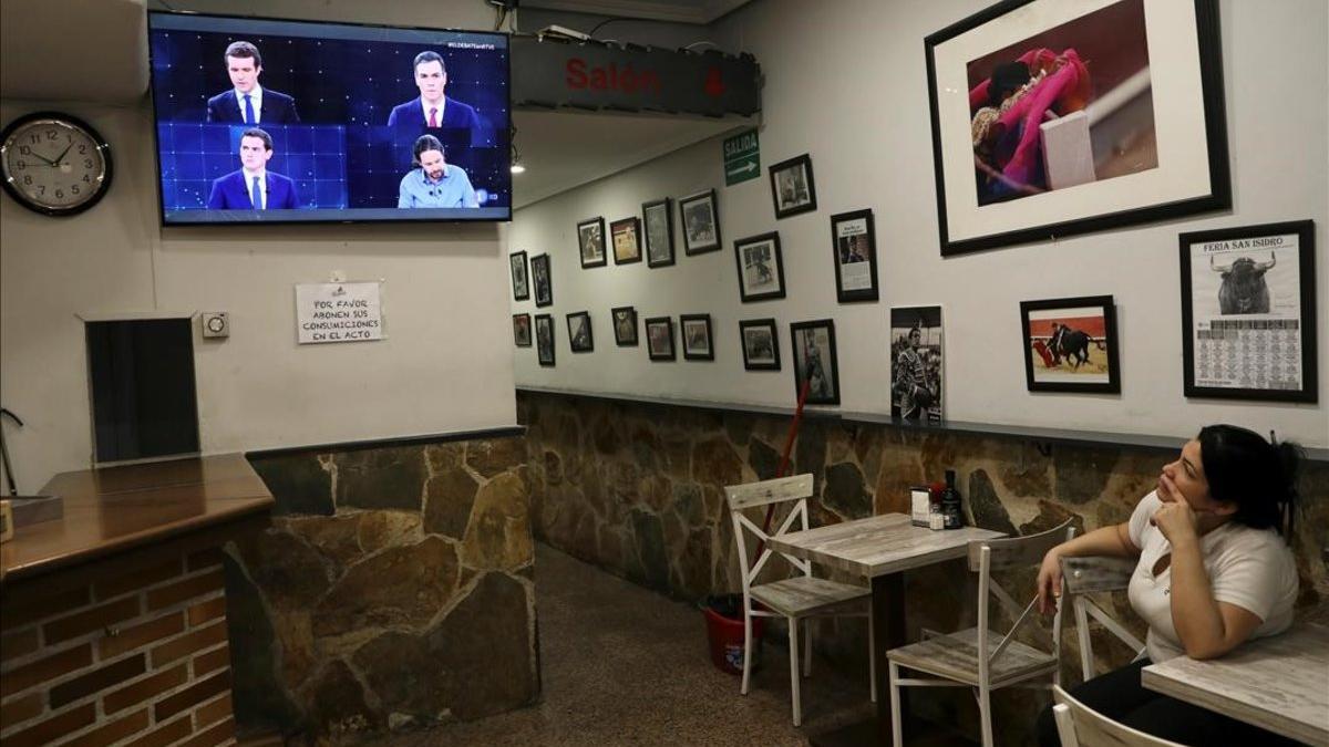 Una empleada de un bar mira el debate de TVE por televisión