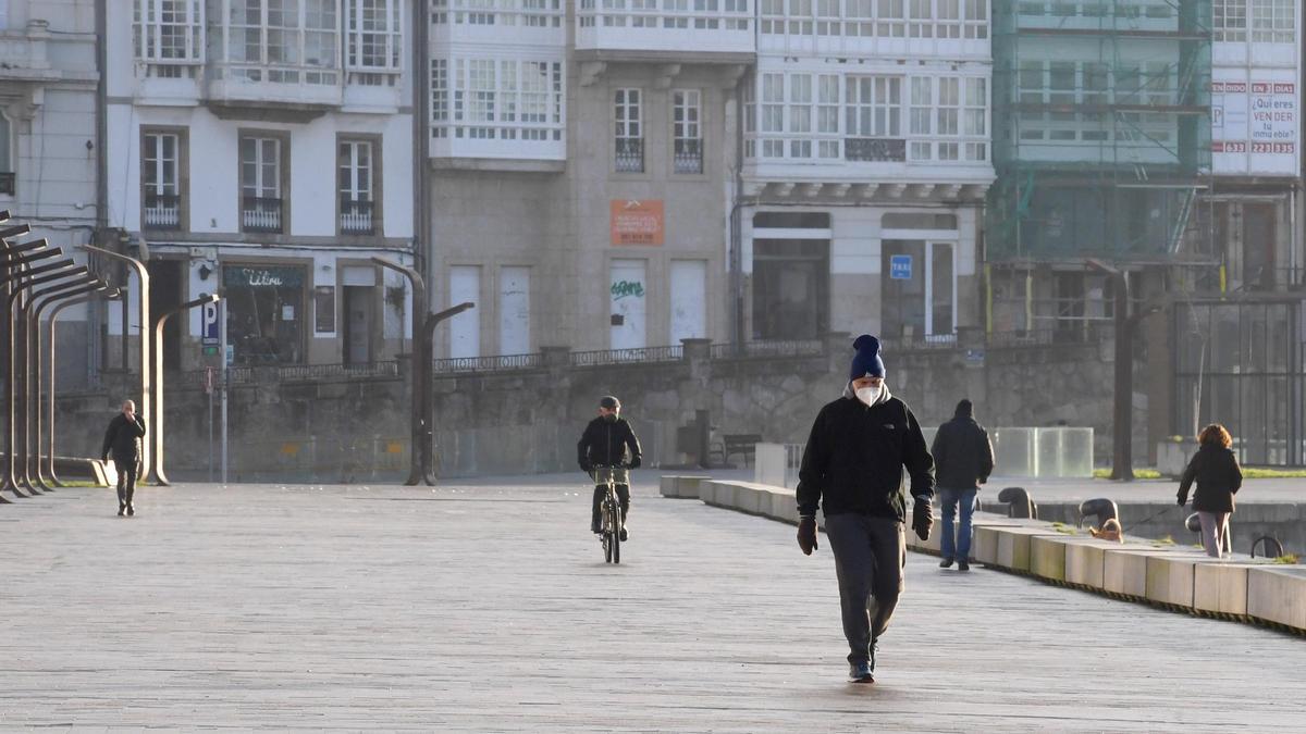 Viandantes en la Marina de A Coruña una mañana soleada de invierno.