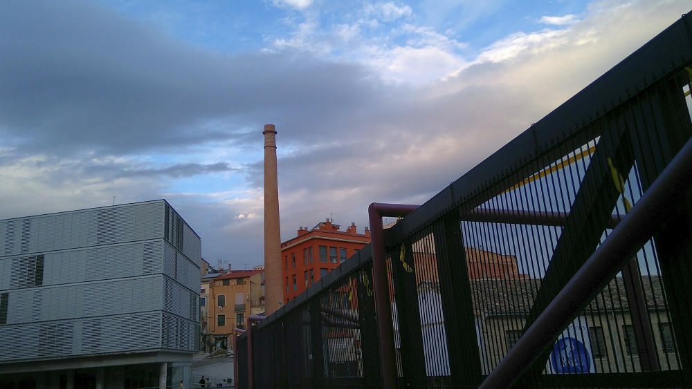 Nuvolades. La vella fàbrica frisa per tocar amb el seu llarg dit els núvols que passen.