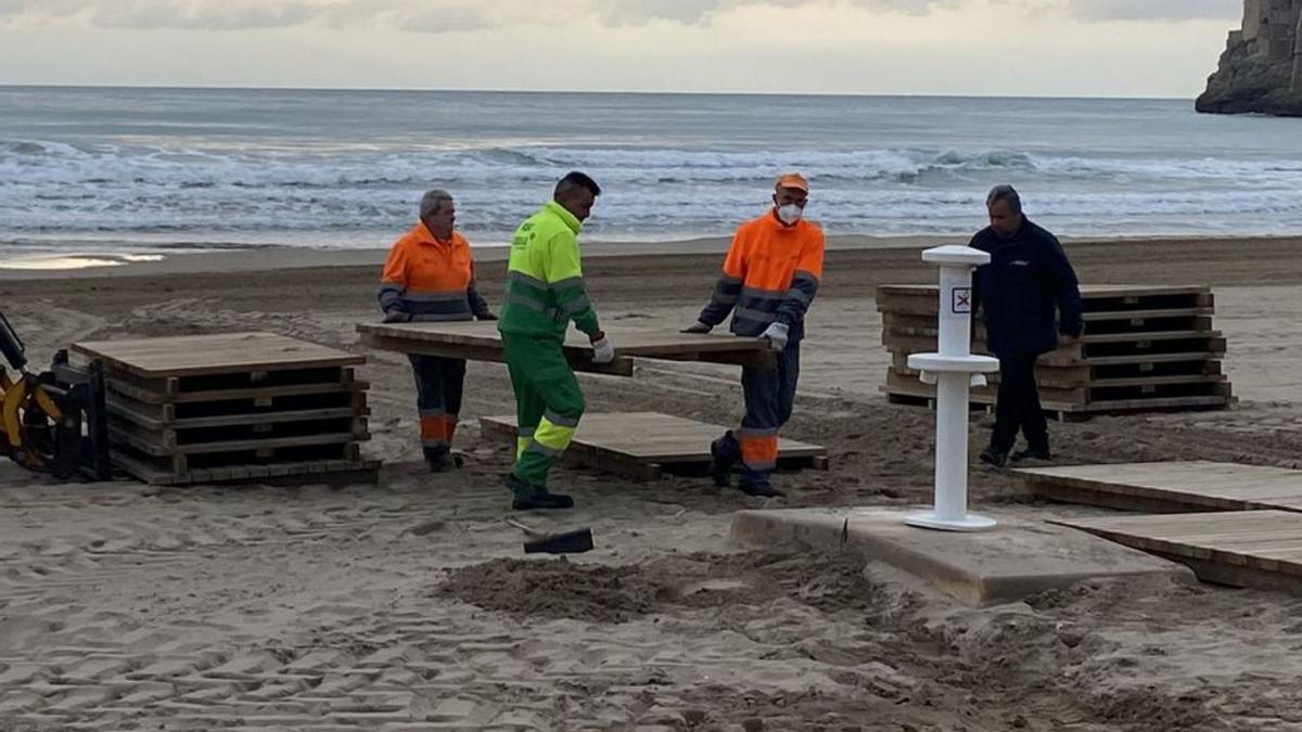 Los opearios ultiman la instalación de pasarelas en las playas de Peñíscola. | ALBA BOIX