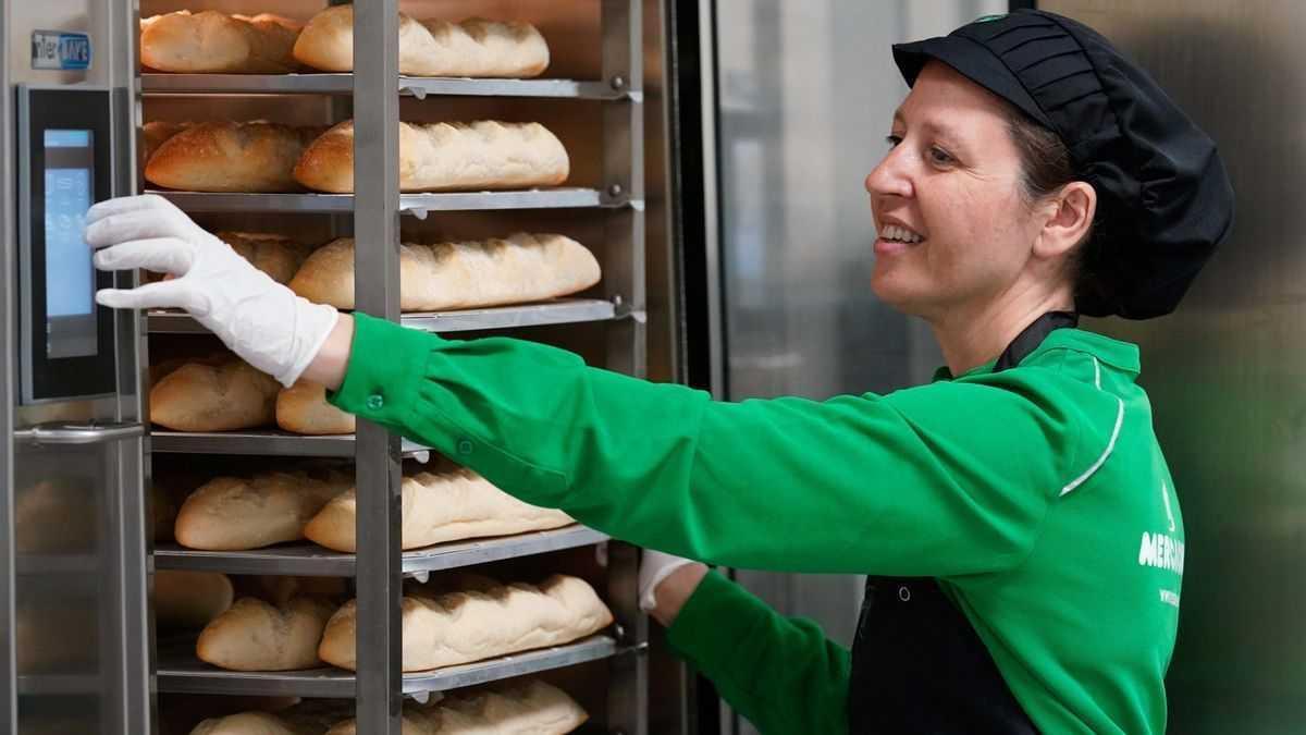 Una treballadora de Mercadona posant el pa a fornejar