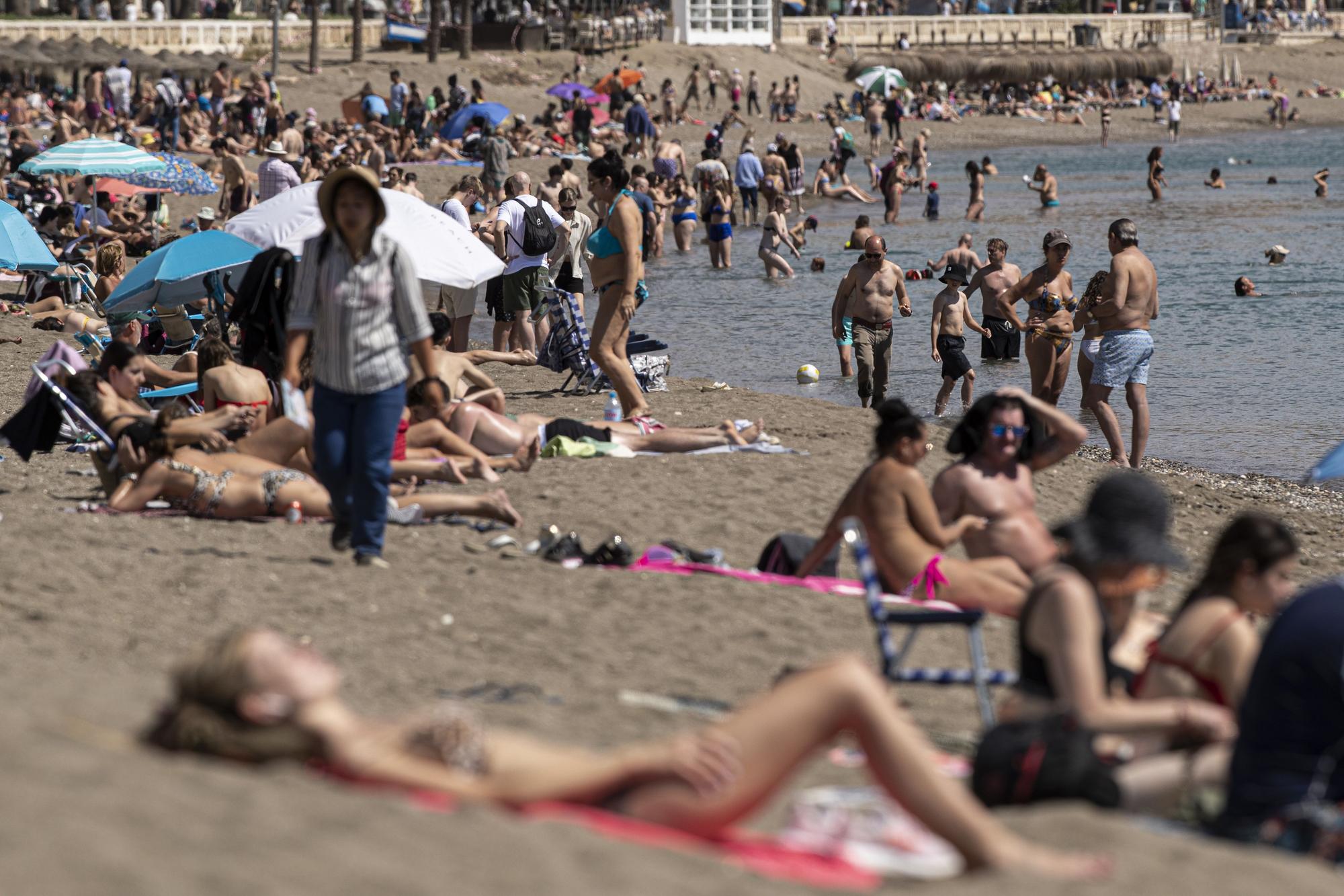 Numerosas personas disfrutan del buento tiempo en la playa de la Malagueta, en el comienzo de las vacaciones de Semana Santa, hoy sábado, en Málaga