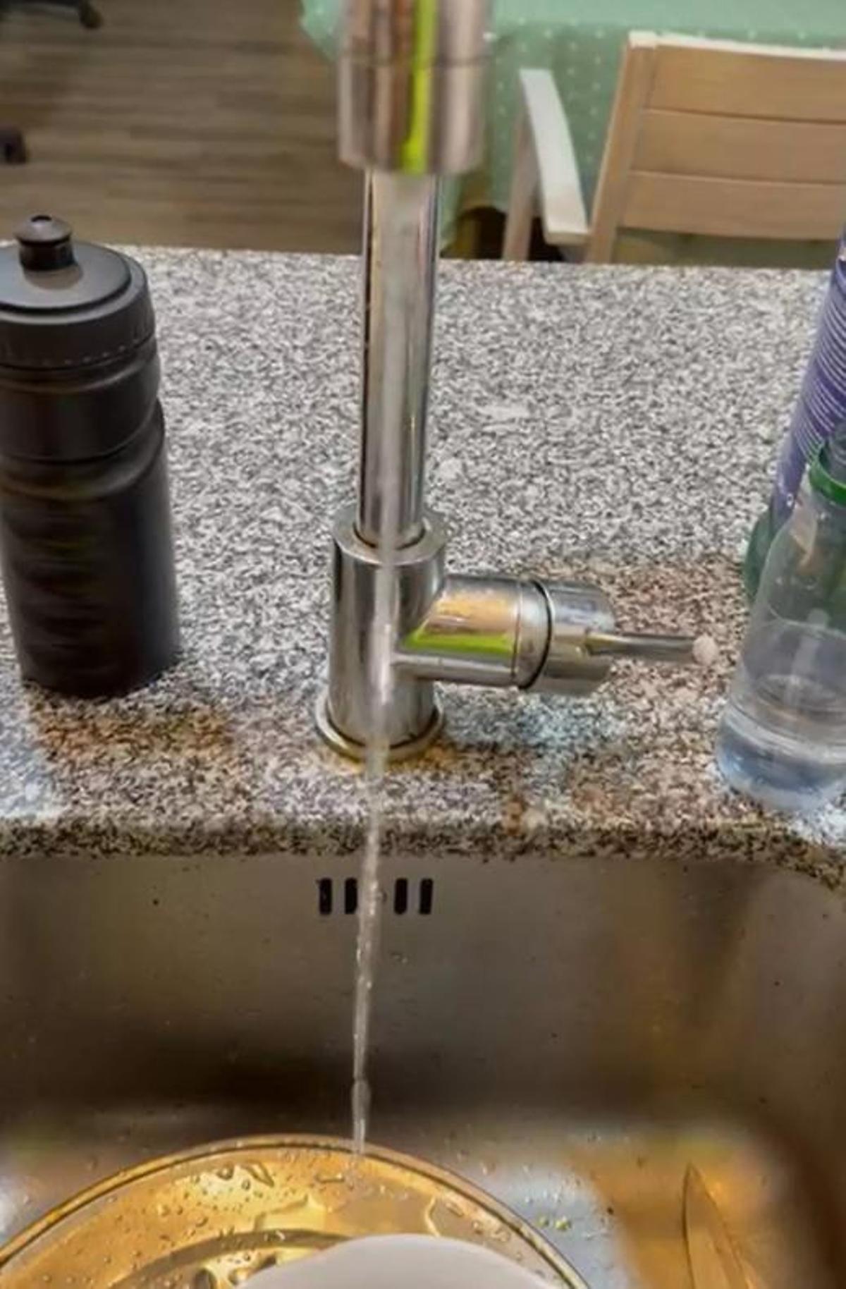 Hilo de agua que sale del grifo de un negocio de hostelería de María Auxiliadora.