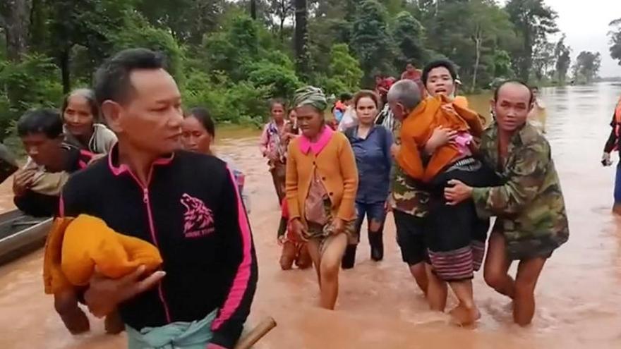 Afectados caminan por el agua hacia zona segura.