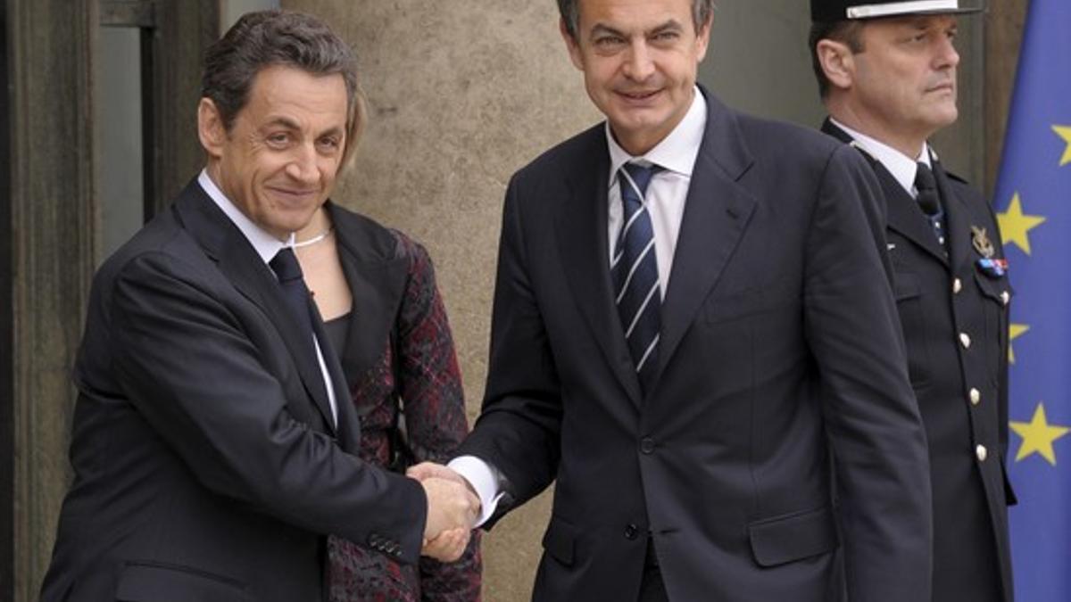 Nicolas Sarkozy saluda a José Luis Rodríguez Zapatero, a las puertas del Elíseo, antes de la cumbre internacional, este sábado en París.