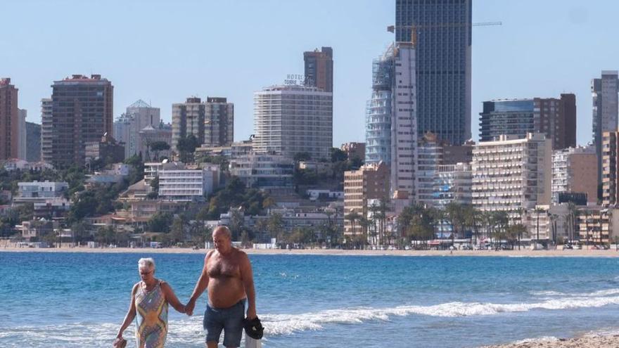 Una pareja pasea por una playa valenciana