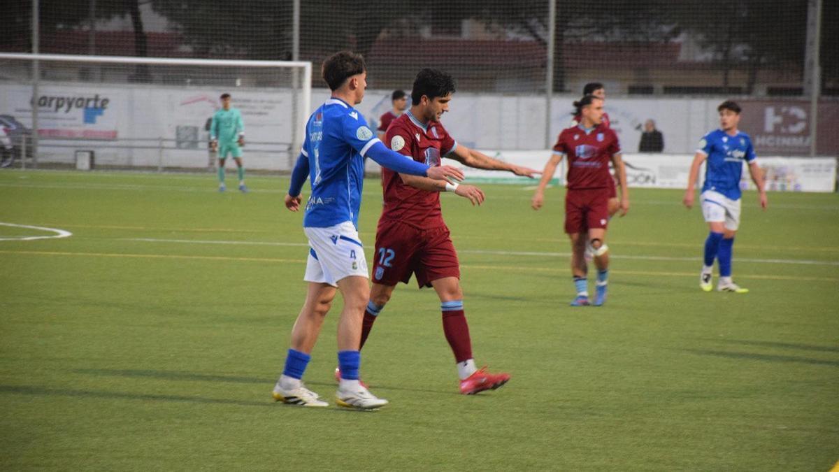 Borja Domingo trata de zafarse del marcaje de Carlos Fernández.