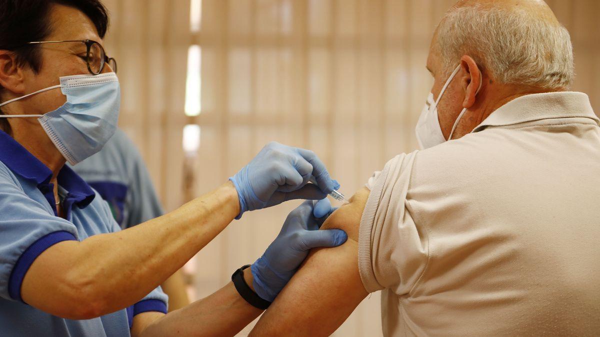 Un enfermero vacuna a un hombre mayor.