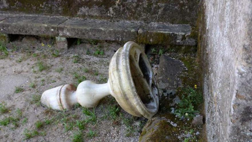 La pila bautismal de alabastro, tirada y semi enterrada en los exteriores de la iglesia de San Ginés de Bamio. // Noé Parga