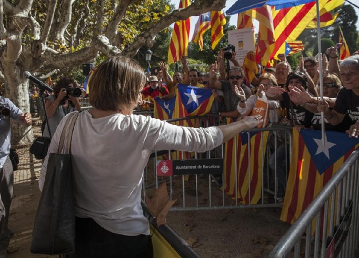 Carme Forcadell, presidenta de la Assemblea Nacional Catalana, saluda a los ciudadanos concentrados ante el Parlament, que debate la ley catalana de consultas.