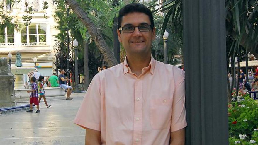 El rector, en la glorieta de su ciudad natal, con una réplica de la Dama d´Elx al fondo.